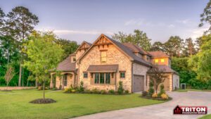 a two story brick house with trees surrounding it