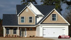 A tan and white two-story suburban house with a dark gray roof
